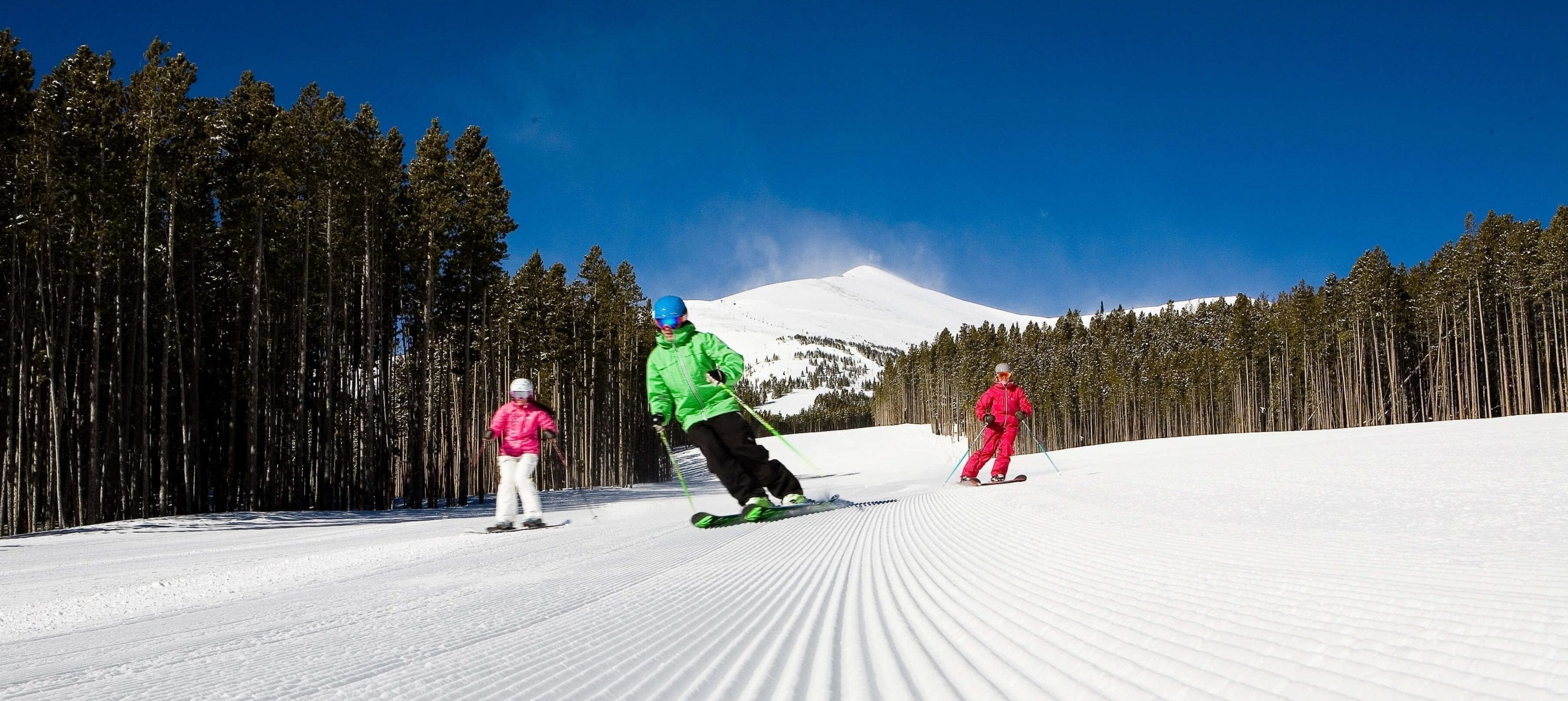 A group of skiers on groomed terrain at Breckenridge Ski Resort.
