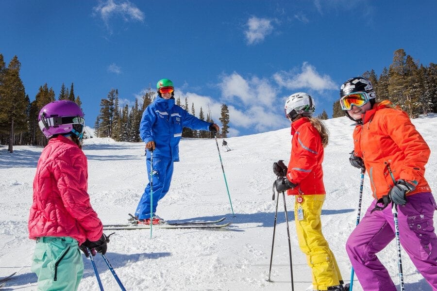 A ski school group talking to each other on a sunny day at Breckenridge.