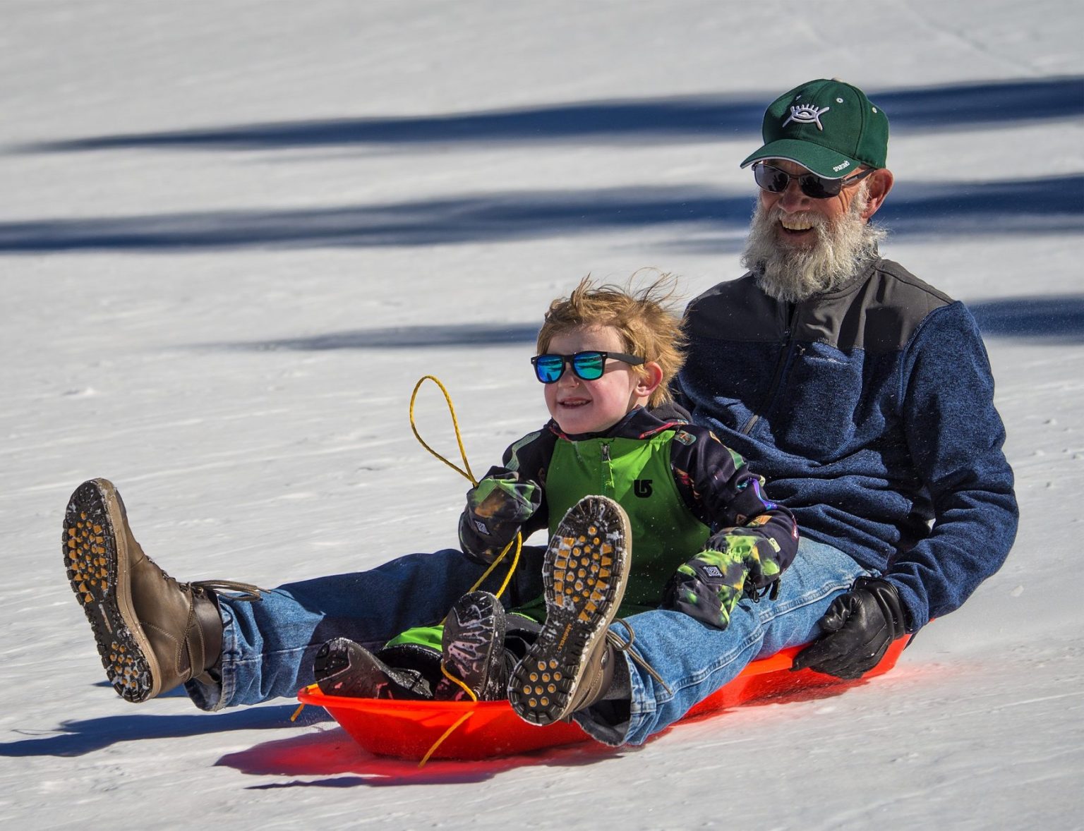 Grandfather and grandson sledding in Breckenridge