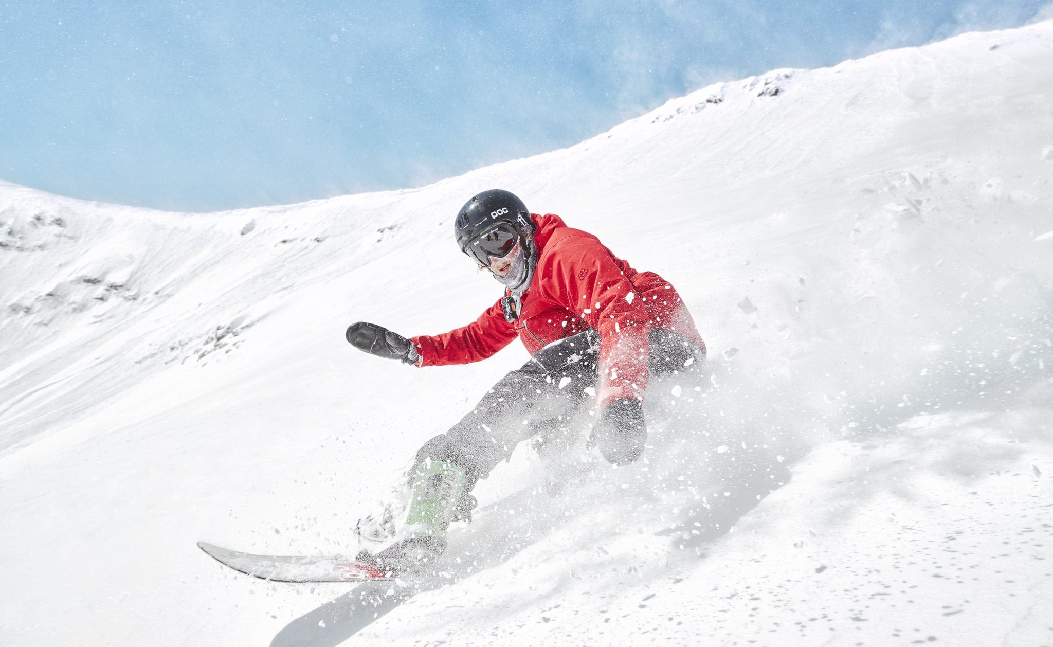 A snowboarding riding powder at Breckenridge Ski Resort.