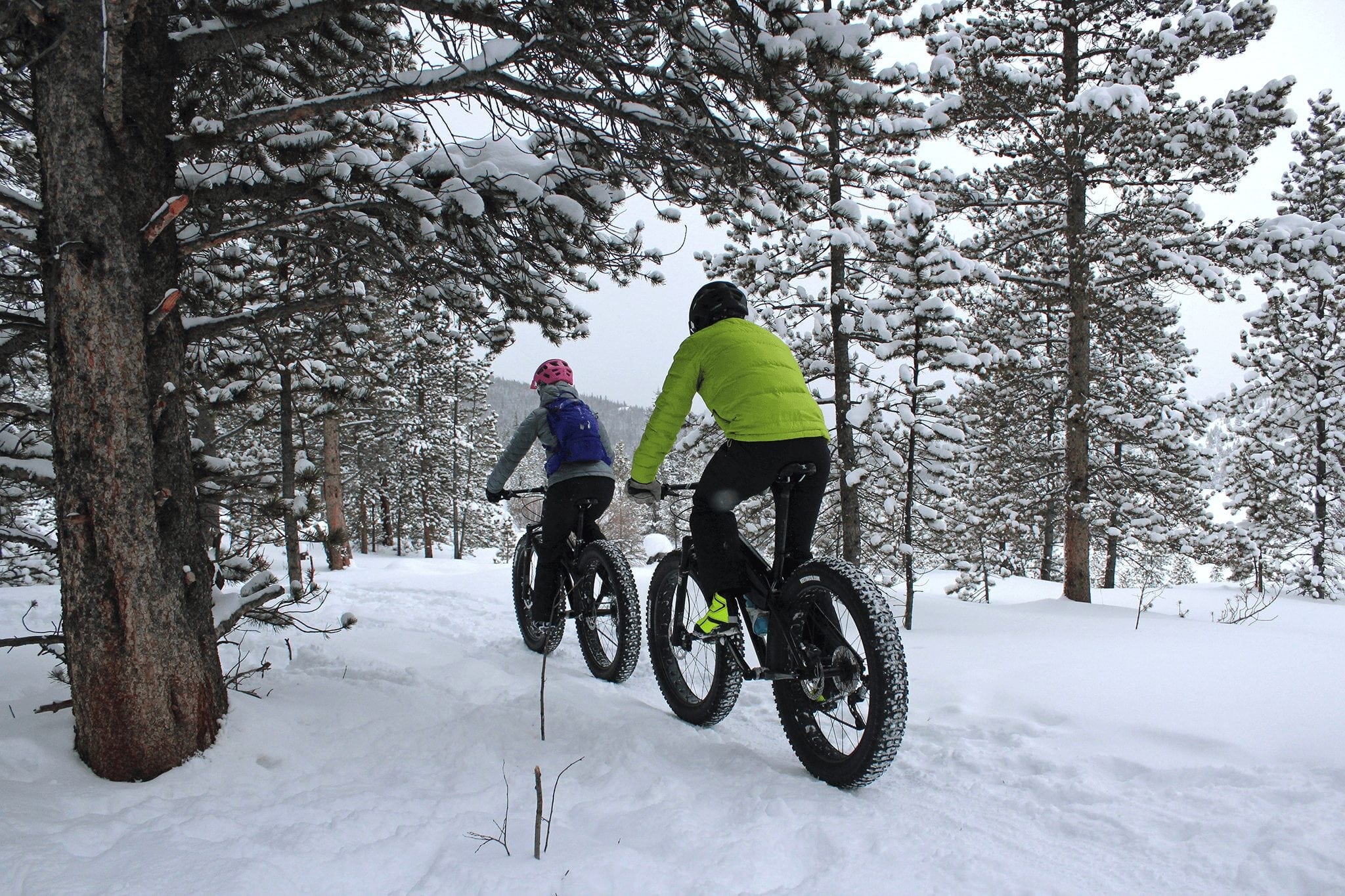 Two people fat biking on a winter trail in Breckenridge, Colorado