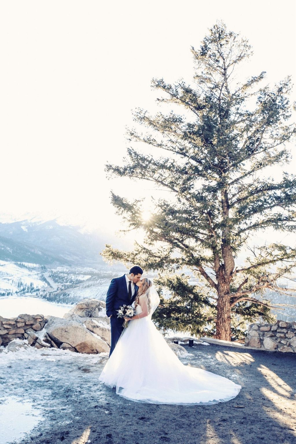 Bride and Groom kissing on the mountainside in Breckenridge for Winter Wedding. Wedding Resources.