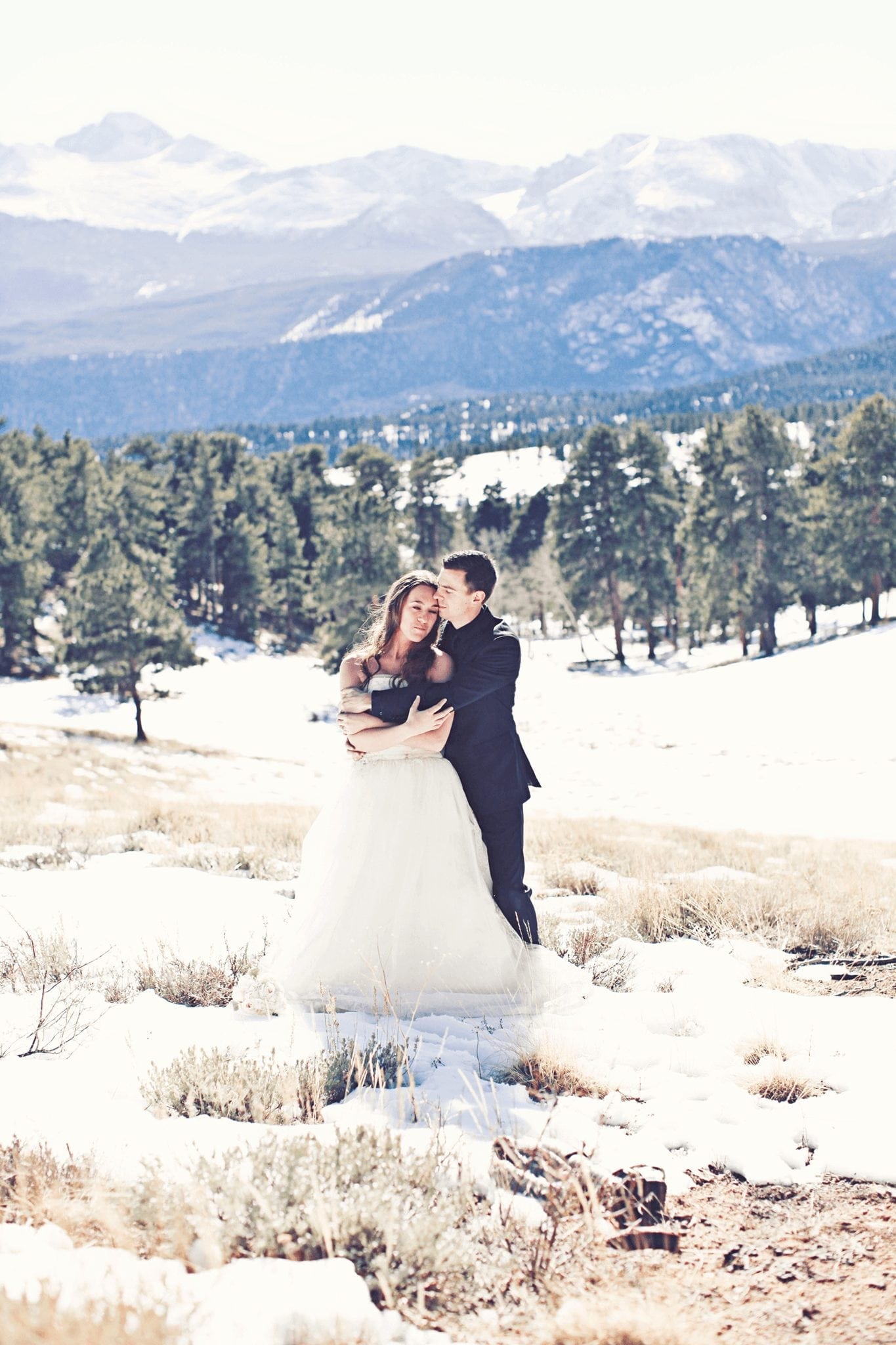 Bride and Groom posing on Breckenridge mountainside for a Winter Wedding