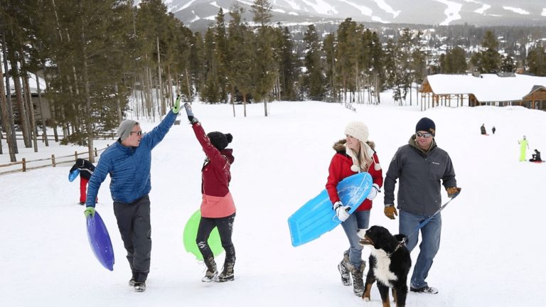 A family sledding with a dog in Breckenridge