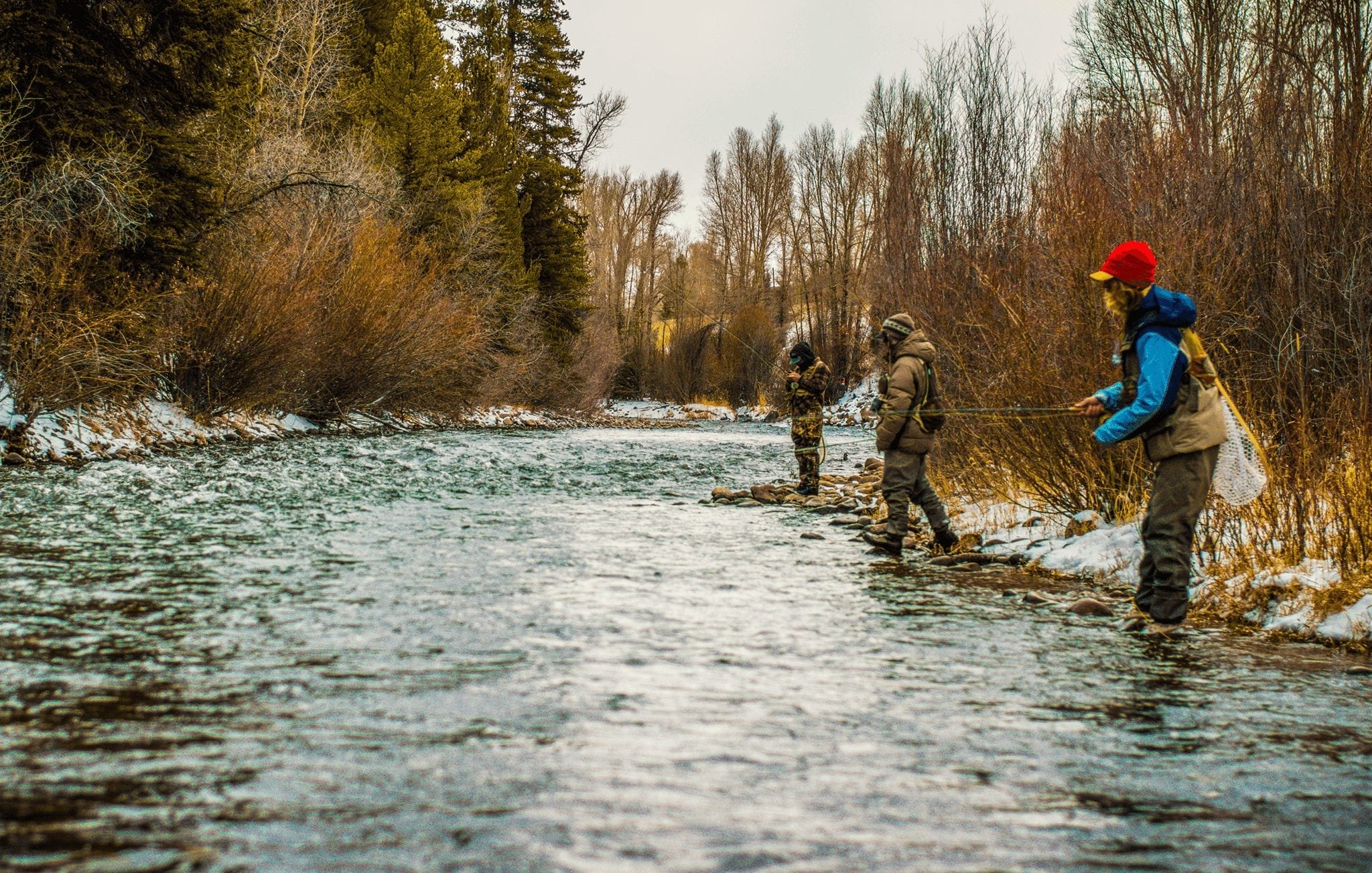 A group fly fishing in the river during winter in Breckenridge
