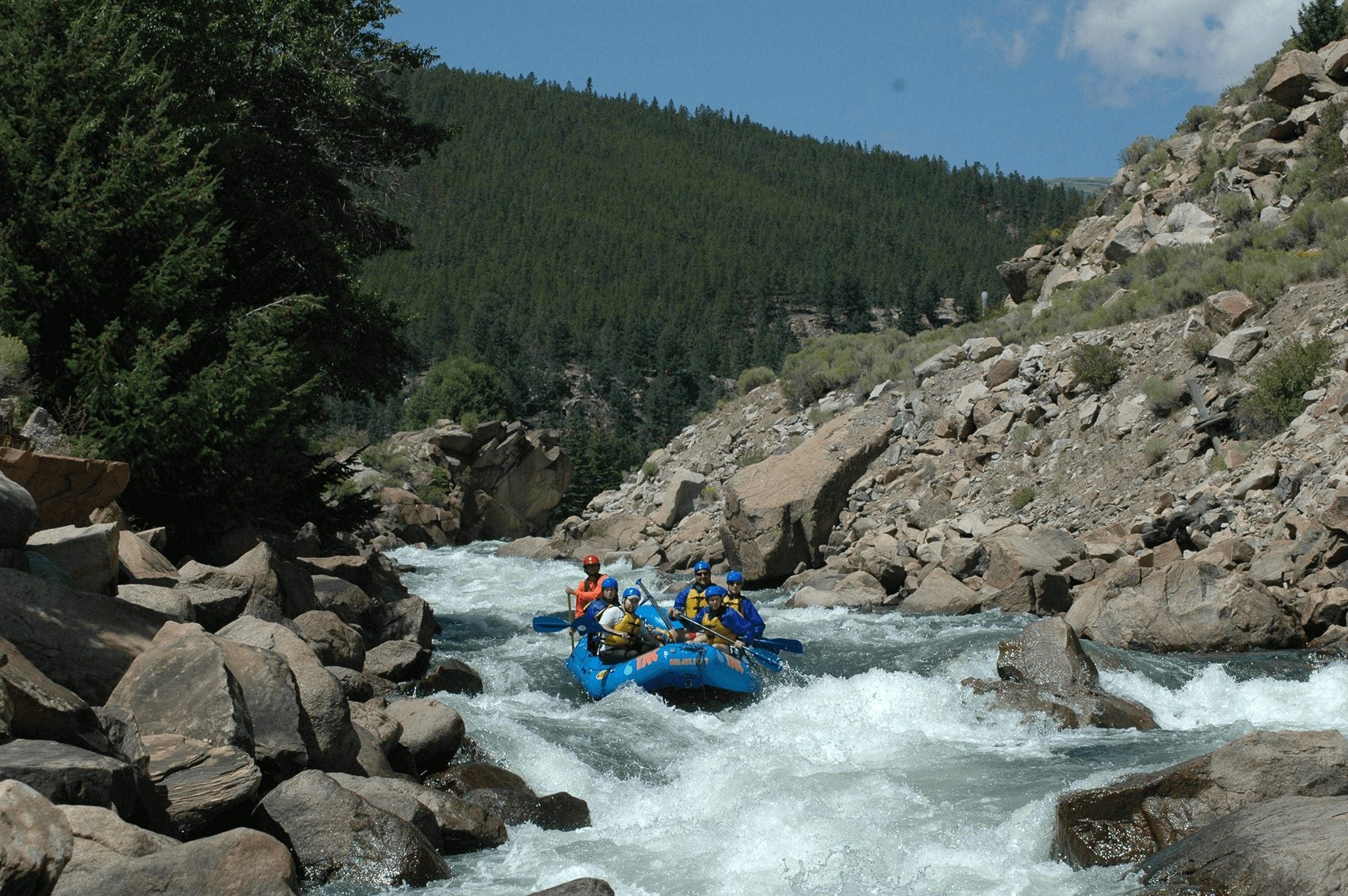 A group rafting against a scenic mountain view in Breckenridge