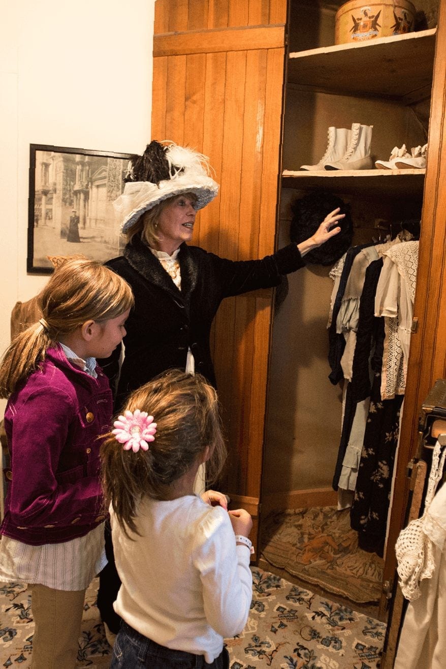 Breckenridge Historical Alliance museum tour guide showing girls historical clothes.