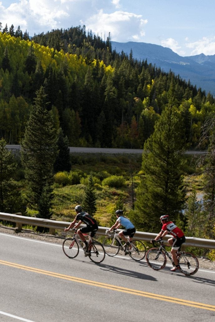 Group of people biking on a road in the mountains of Breckenridge.