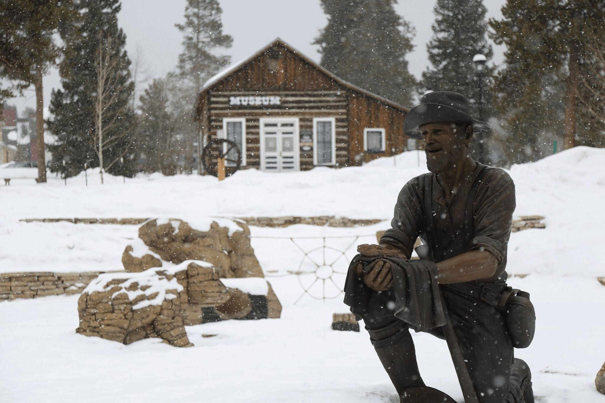 Snow falling in front of museum with statue in Breckenridge Colorado