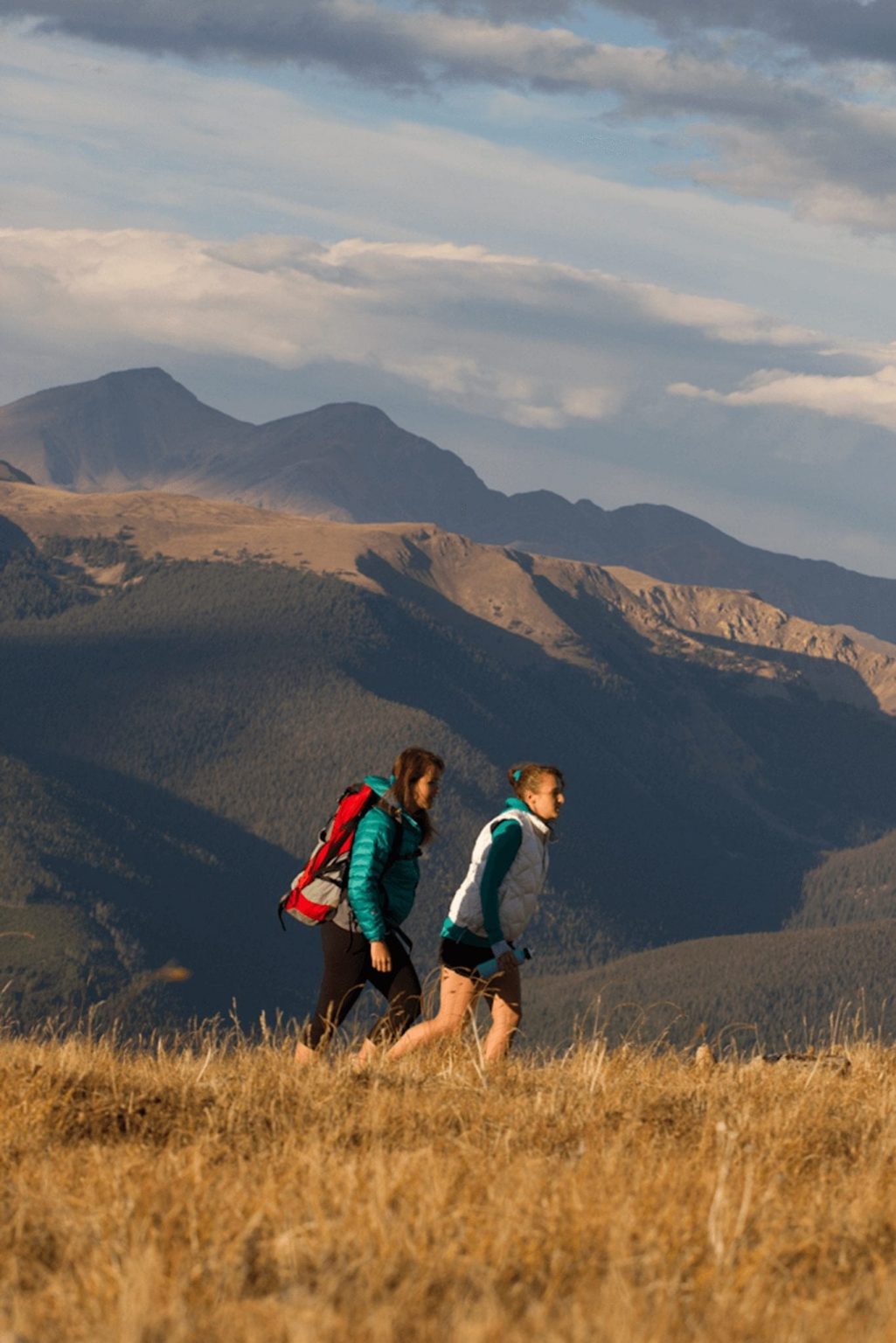 Summer in Breckenridge: girls hiking a field with a mountain view