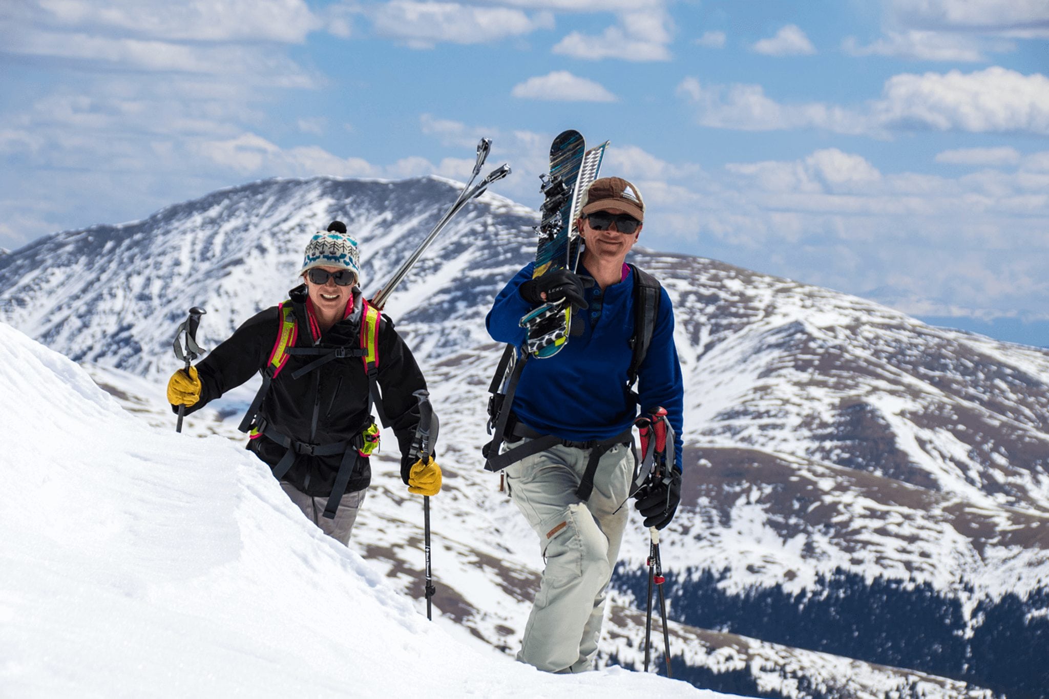 Two female backcountry skiers hiking above treeline. Hike-to terrain is one of the best winter workouts in Breckenridge.