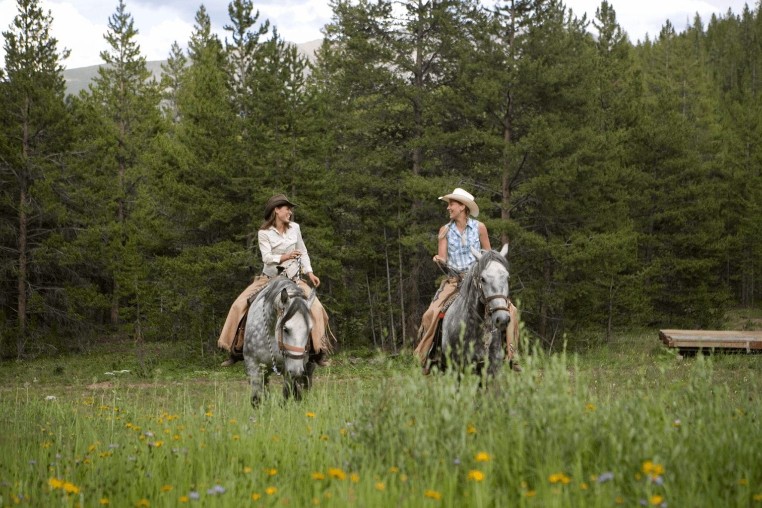 Two women horseback riding in Colorado.