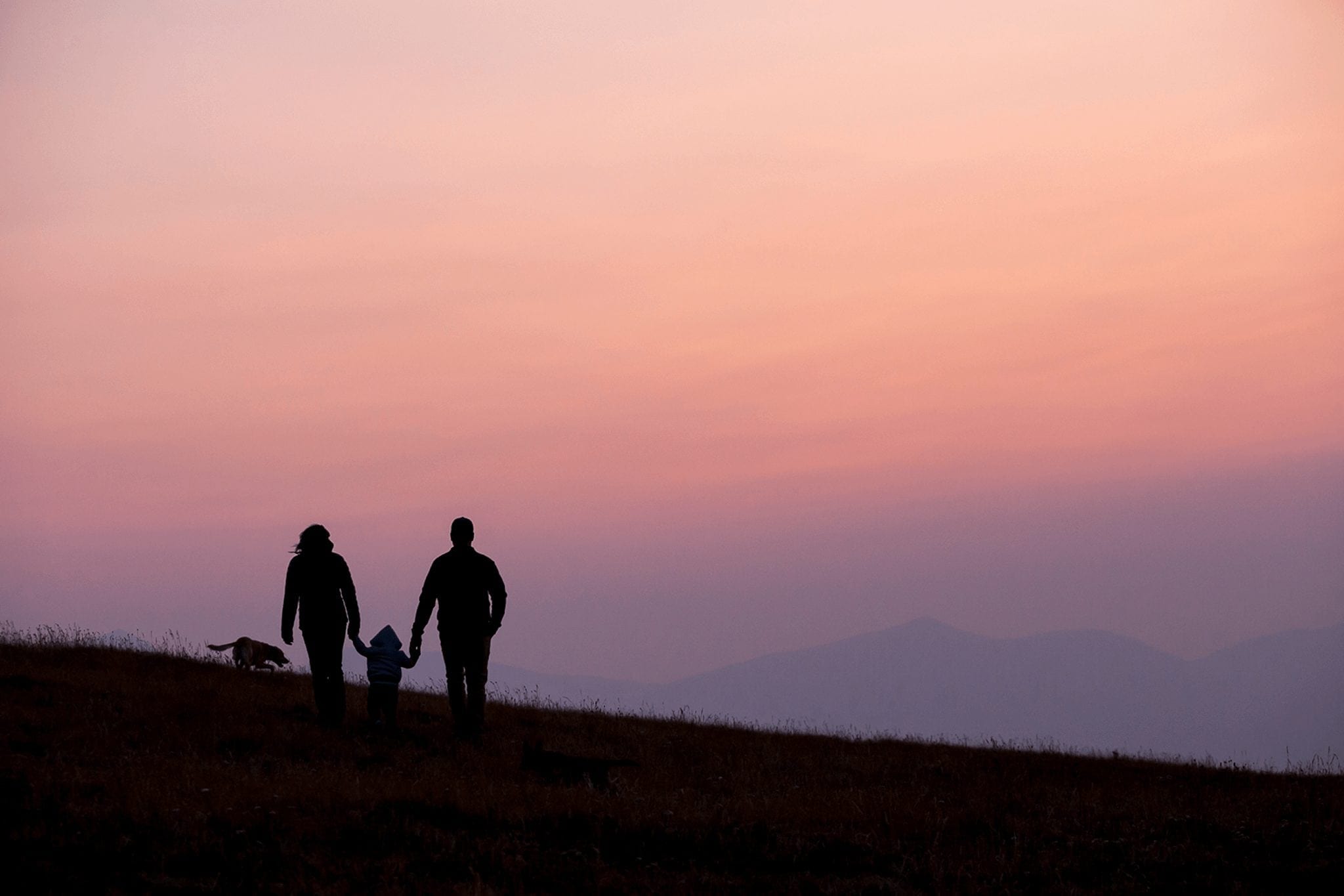 Silhouette of a family on a sunset hike with their dog in Breckenridge. 