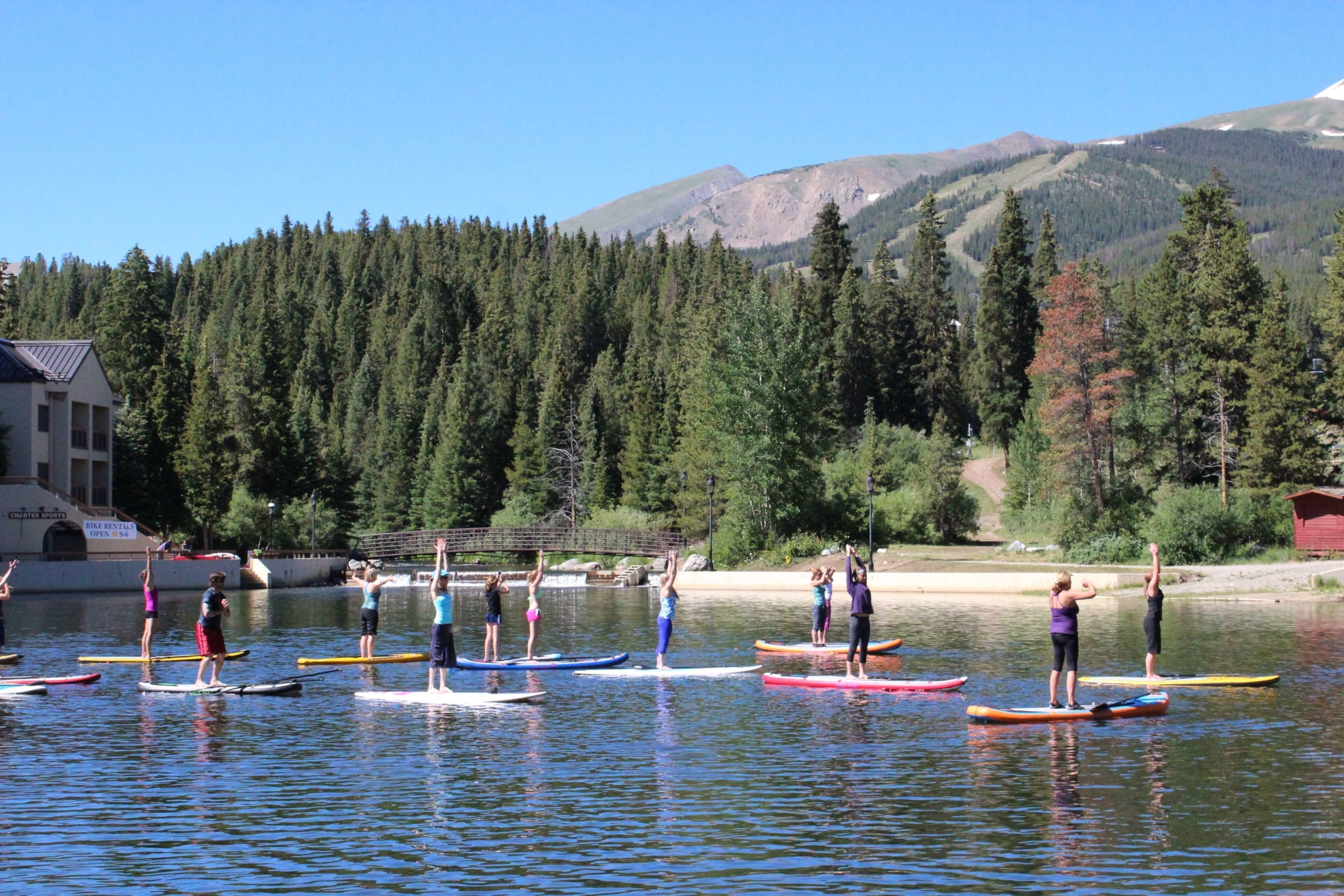 A group of stand up paddleboarders doing yoga on Maggie Pond in Breckenridge