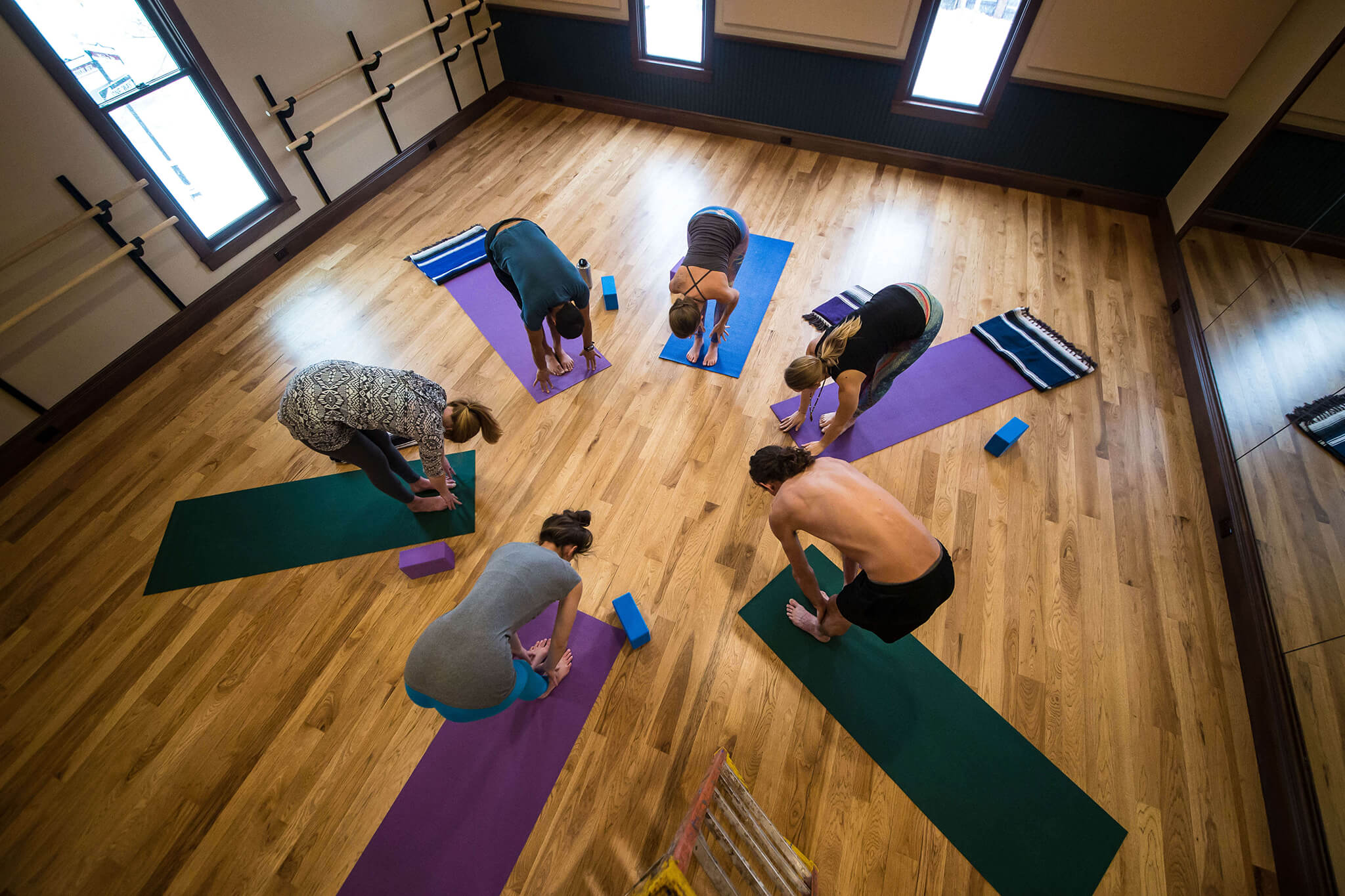 A circle of people practicing indoor yoga in Breckenridge.