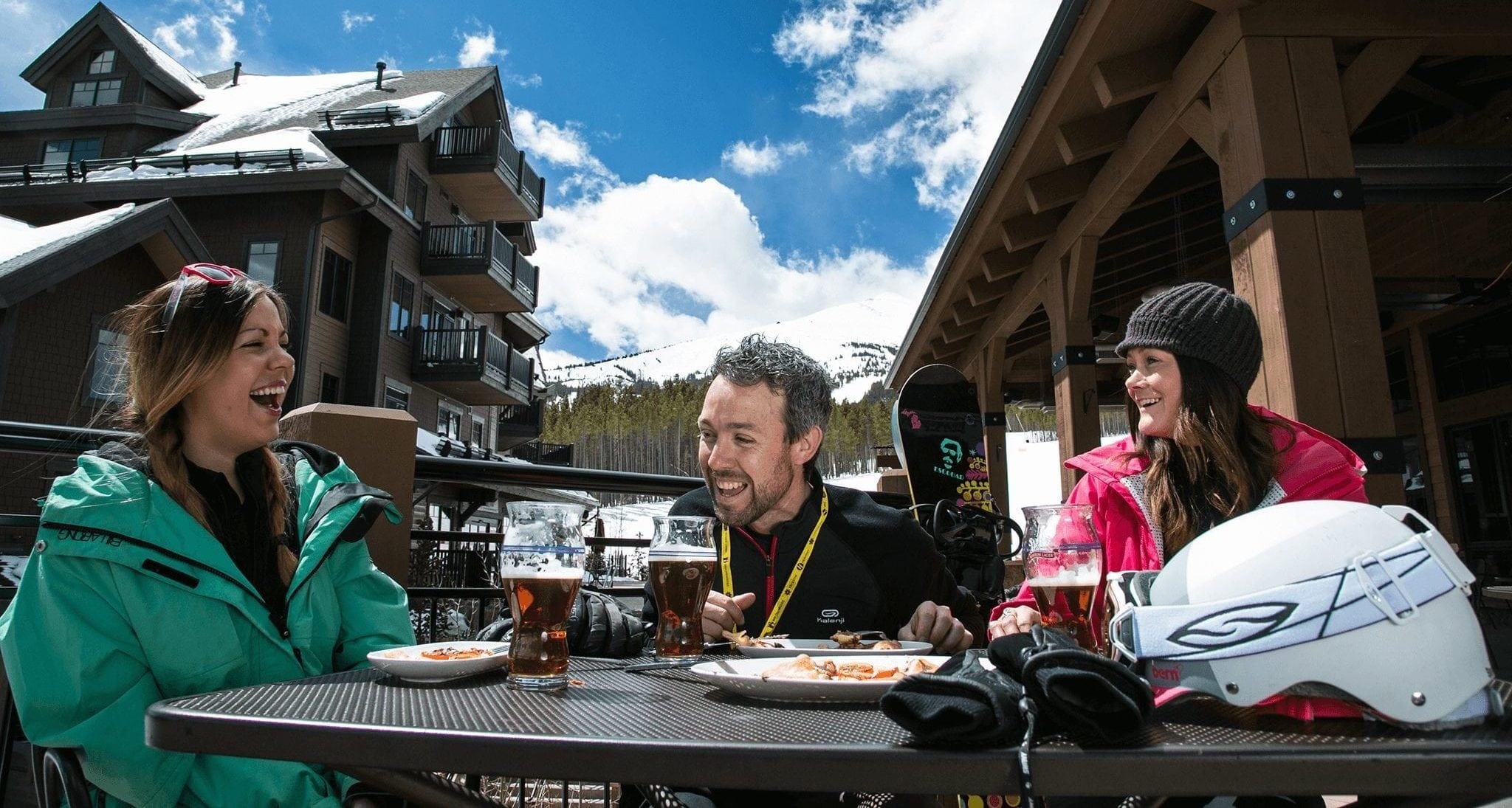 A trio of people having beers at Sevens at the base of Peak 7.