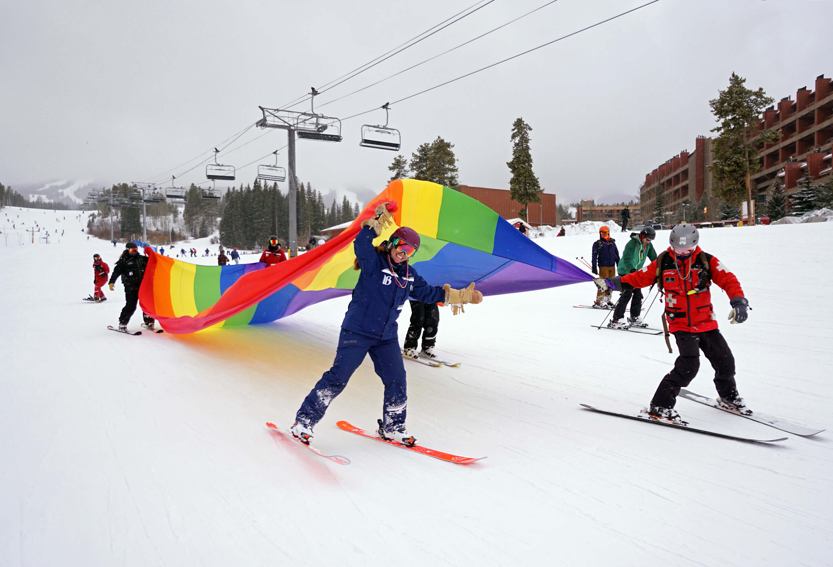 Skiers with a rainbow flag during Breck Pride week