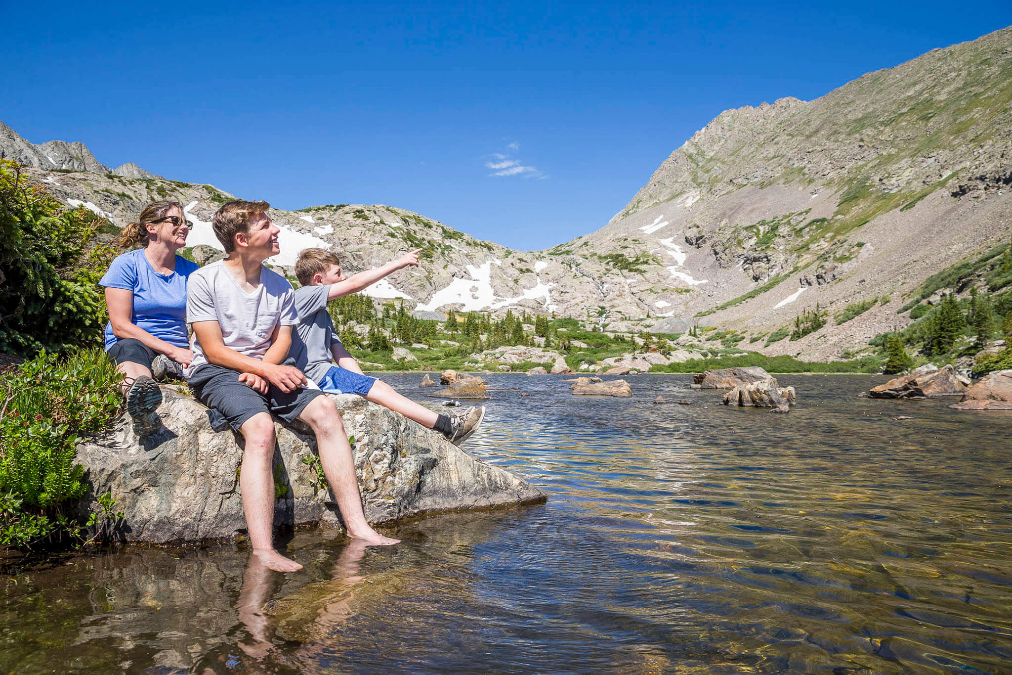 People sitting on a rock in the river at Breckenridge