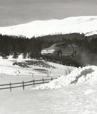 Black and white photo of car jumping over snow in Breckenridge