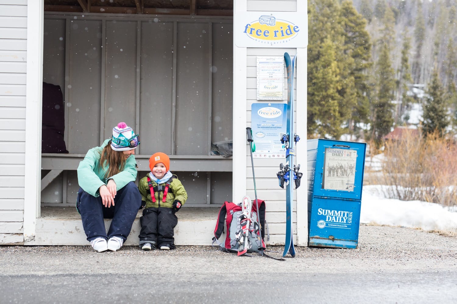 Mom and son waiting at Free Ride bus stop in Breckenridge in winter