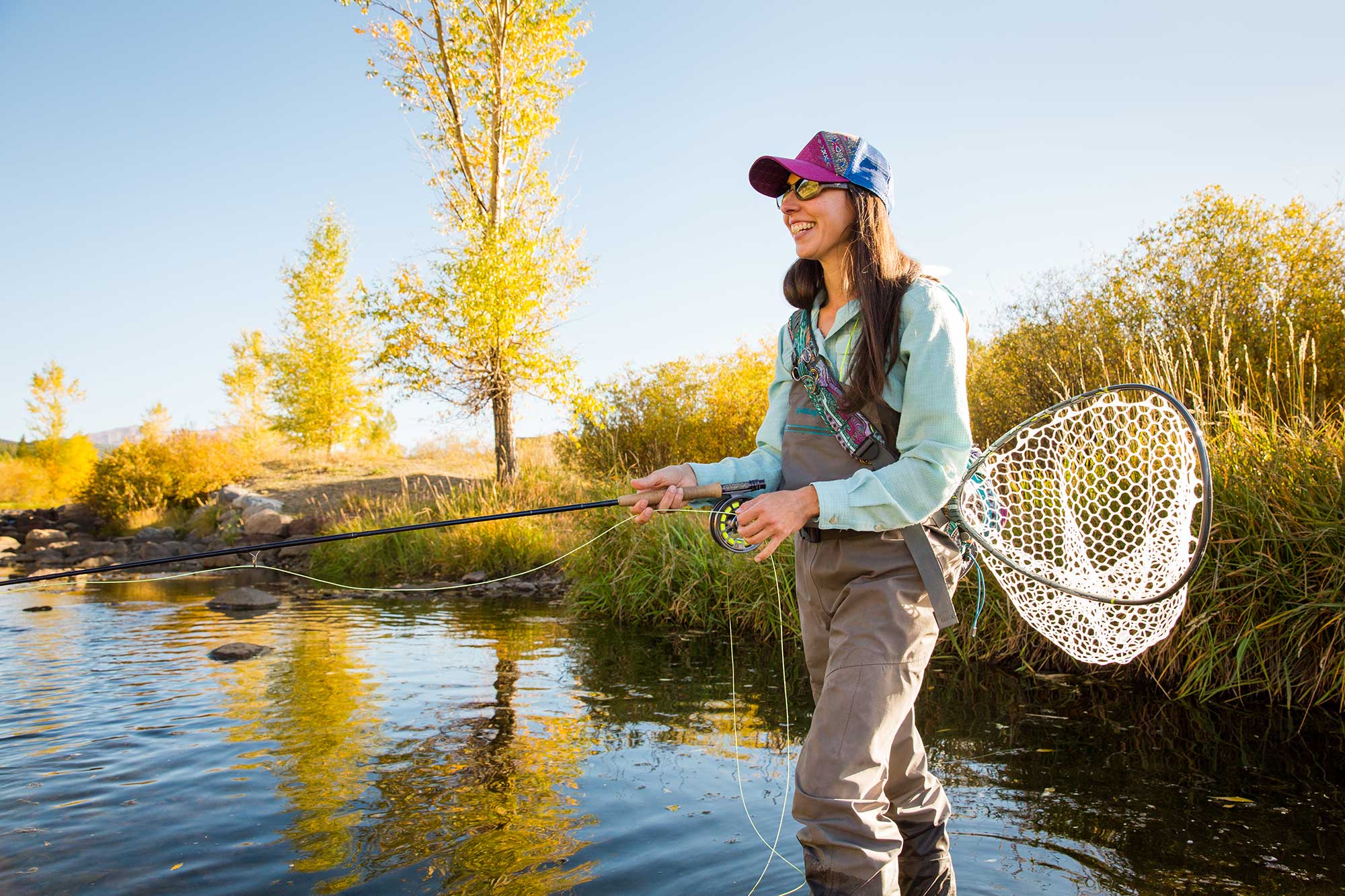 Woman fly fishing in Breckenridge during the fall