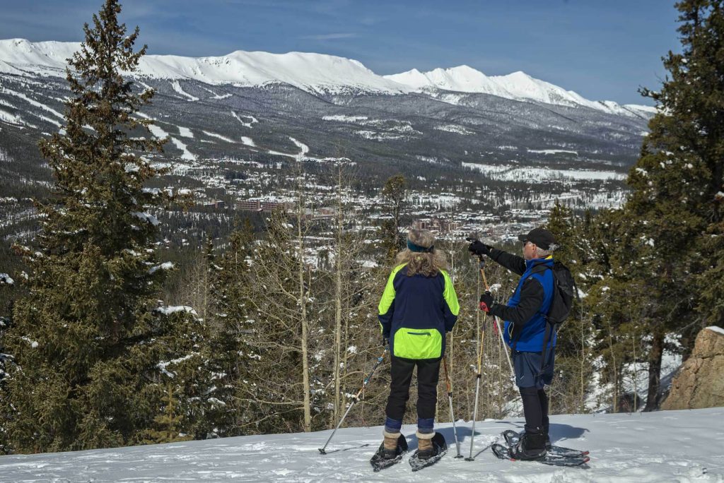 Two people snowshoeing and looking at the Breckenridge mountain views