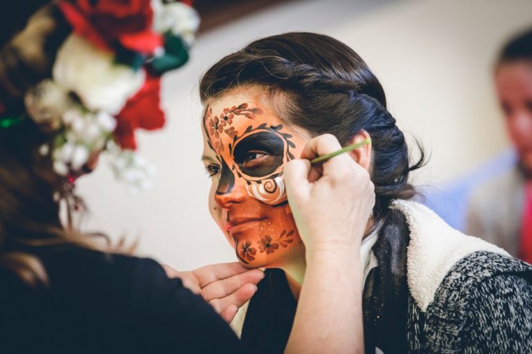 A Dia de los Muertos face getting painted at Breckenridge