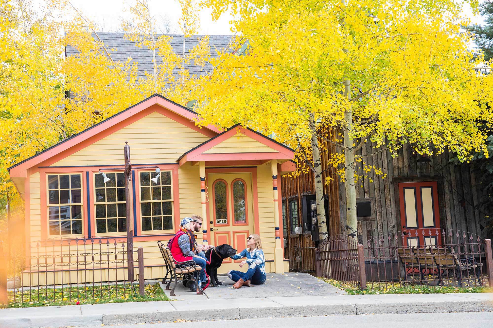 Group of friends sit and relax near historic house in Breckenridge, CO