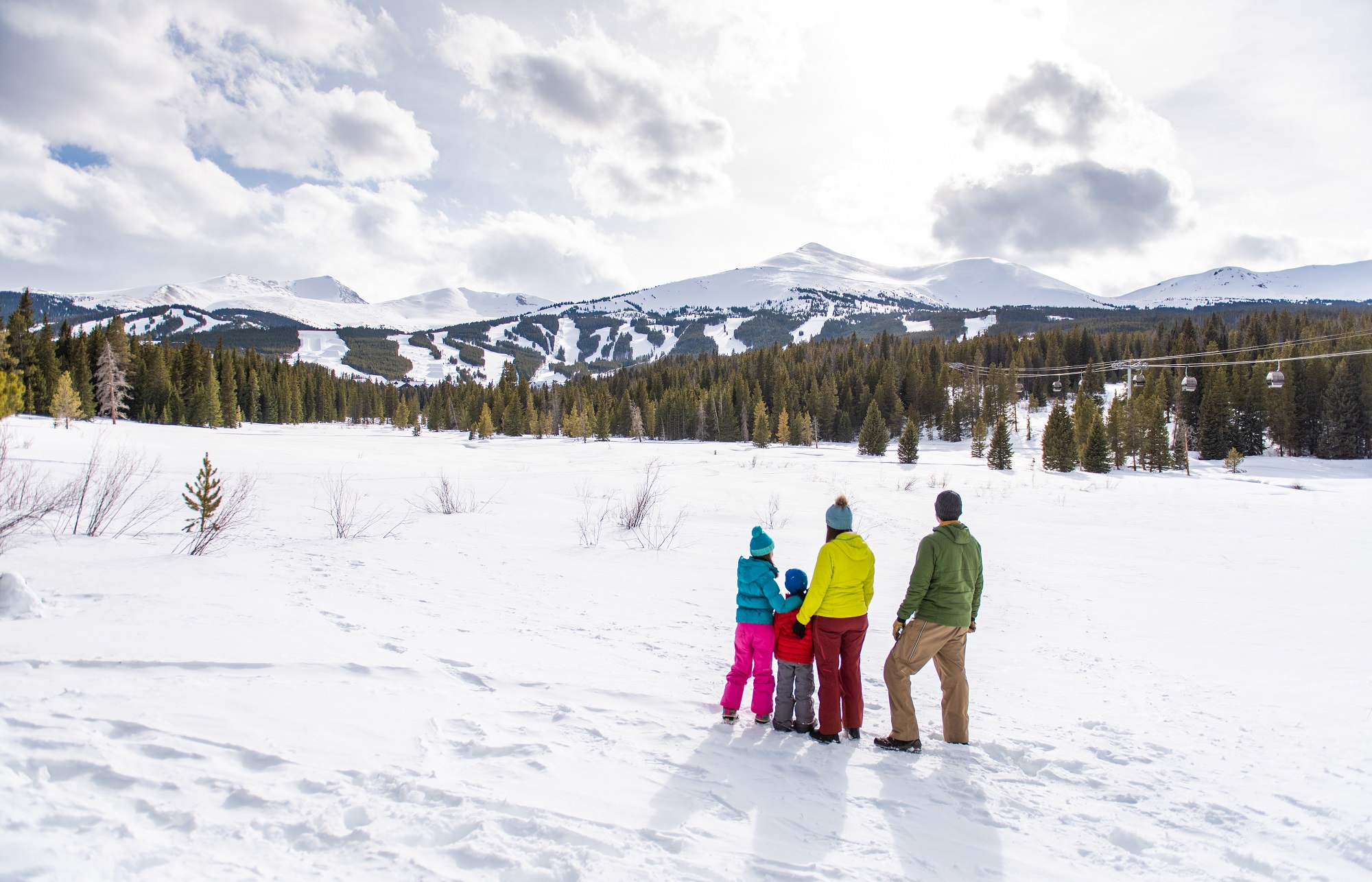 A family standing in the snow enjoying the Breckenridge views