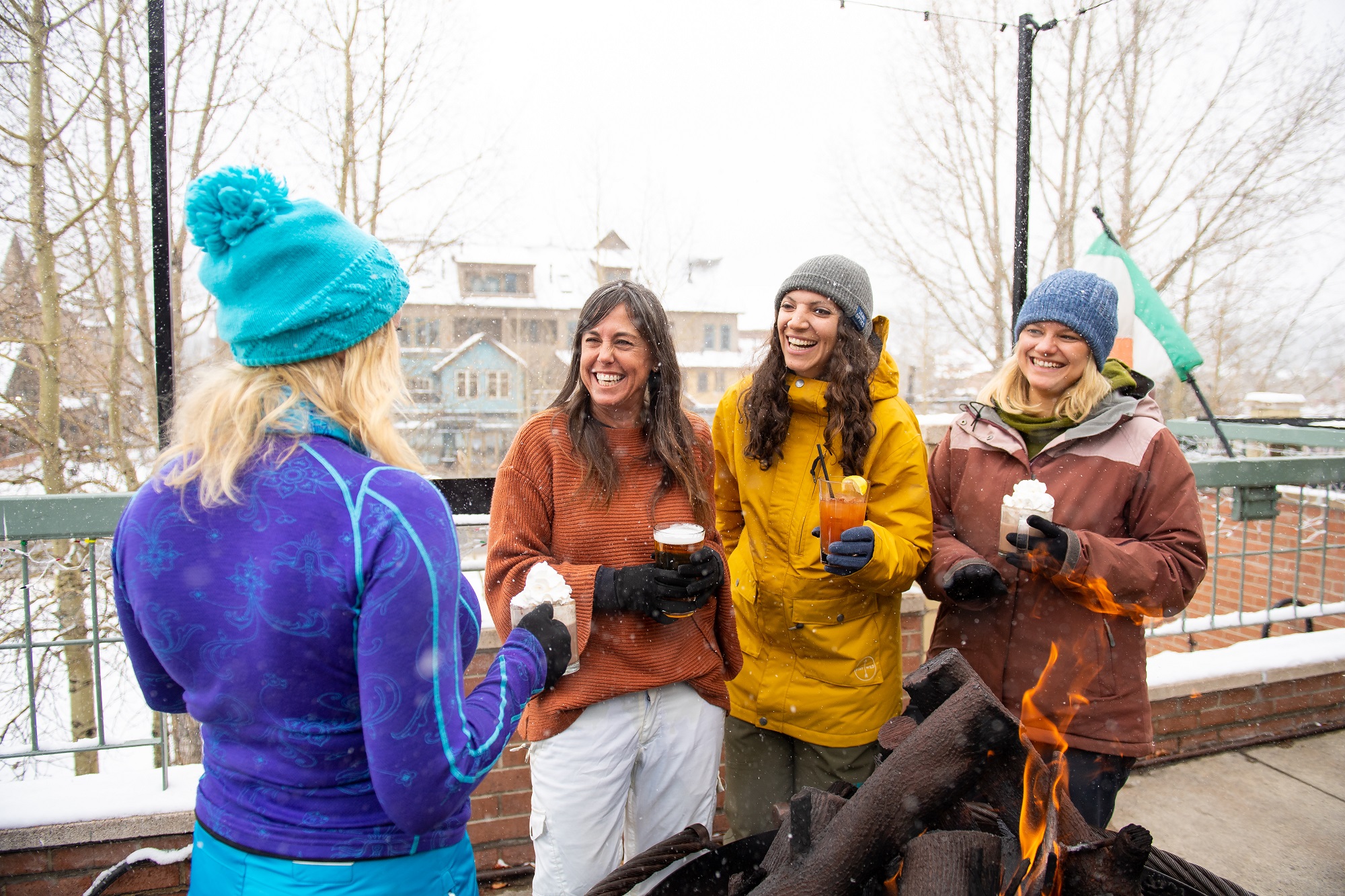 group of women enjoying some drinks by the fire