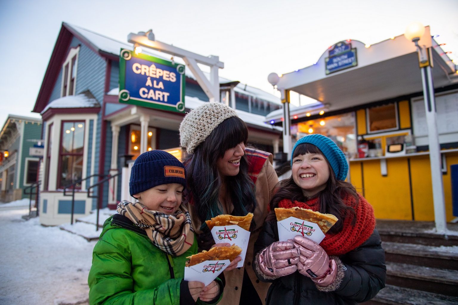 family enjoying crepes in the winter