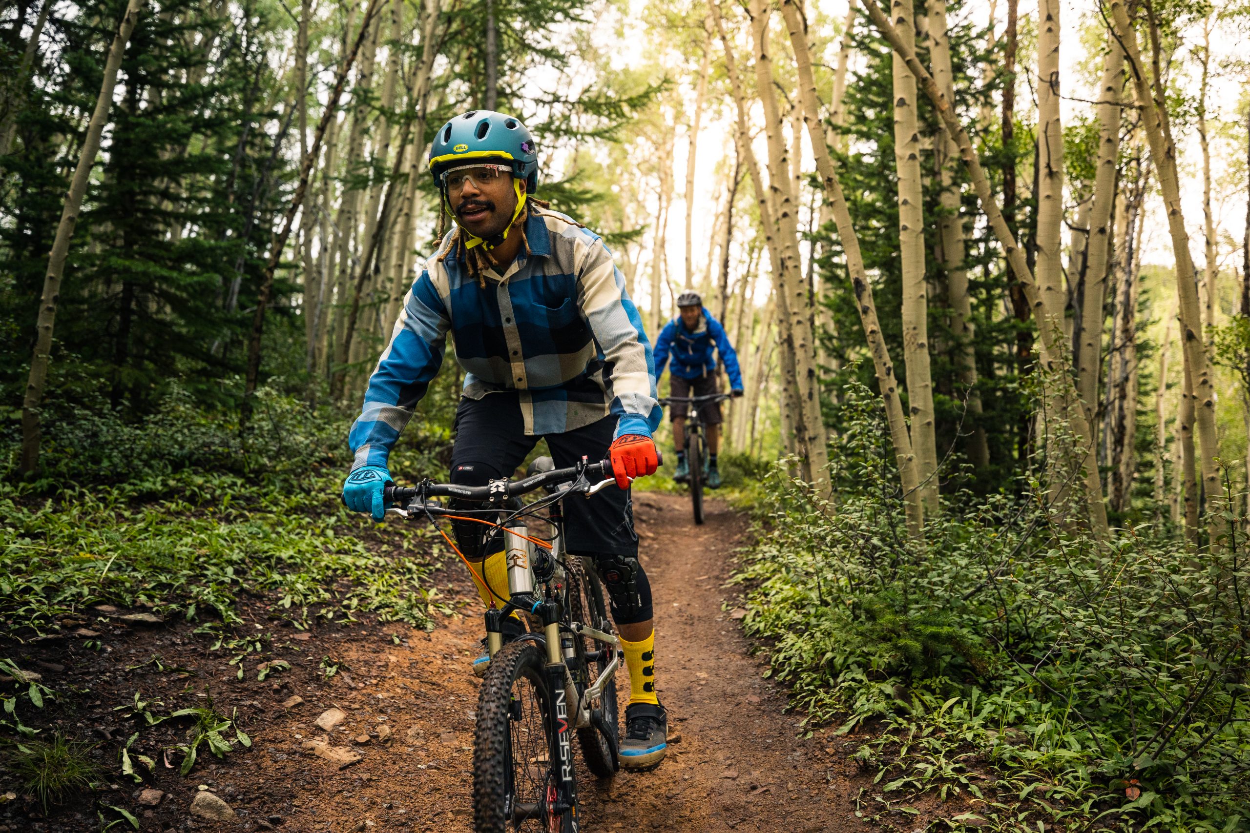 A man mountain biking through the forest in Breckenridge during summer. 