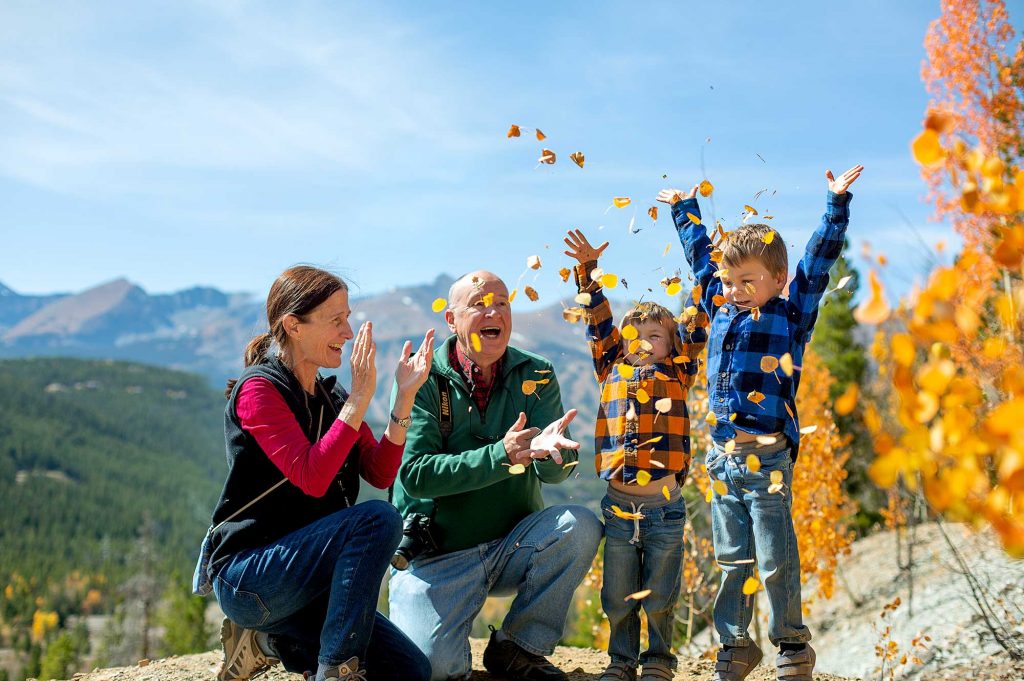 Family throwing leaves while hiking at Breckenridge during the fall