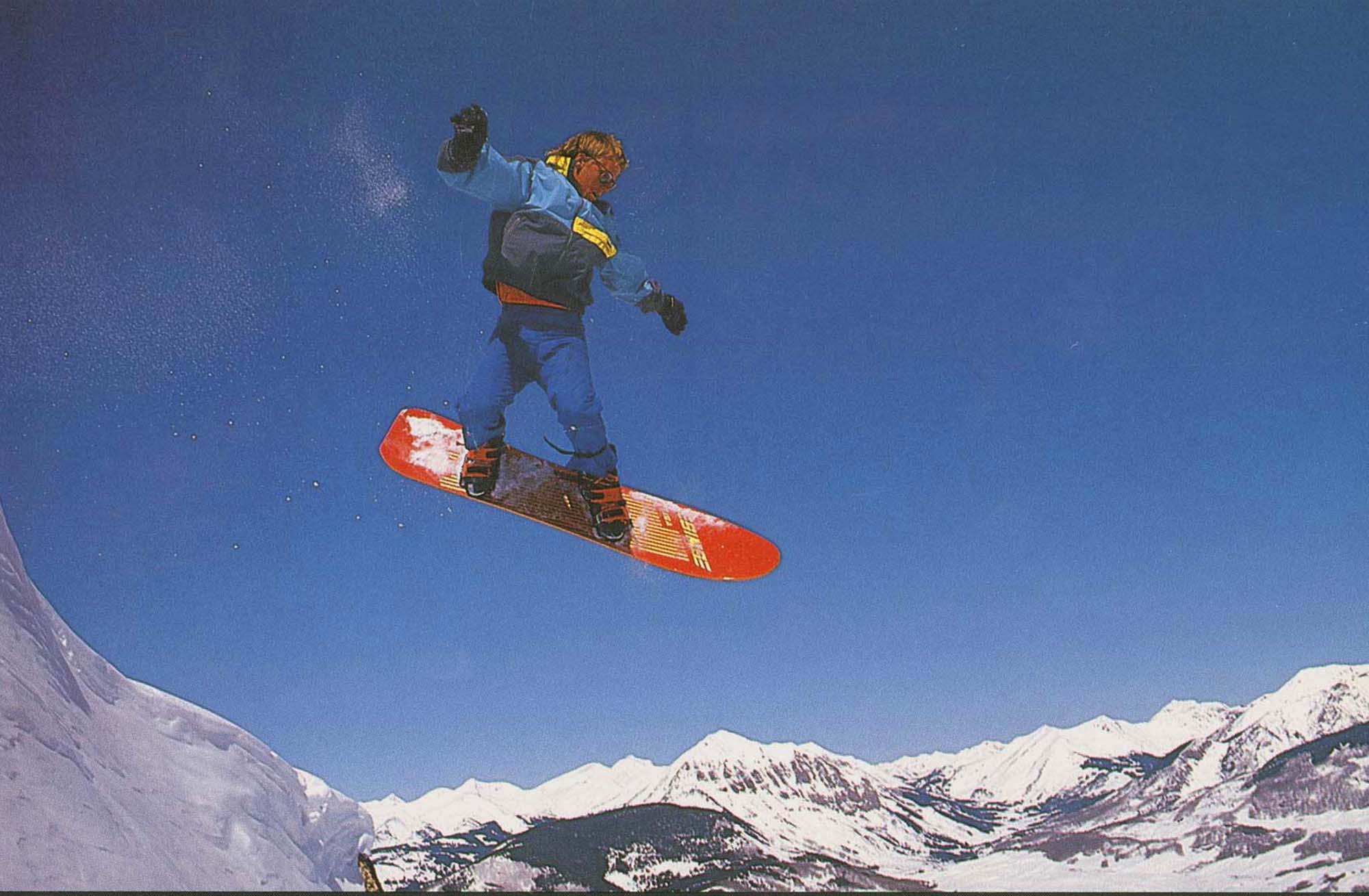 Snowboarder catching air on his snowboard, (Colo.)--1980s