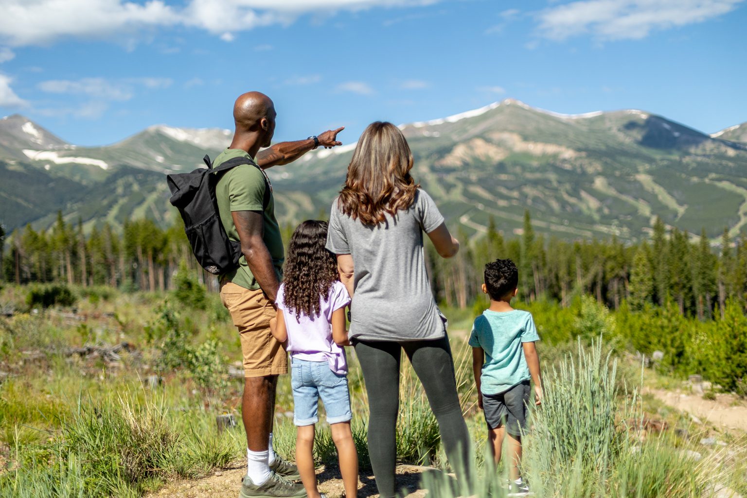 family enjoying a view of mountains on a hike