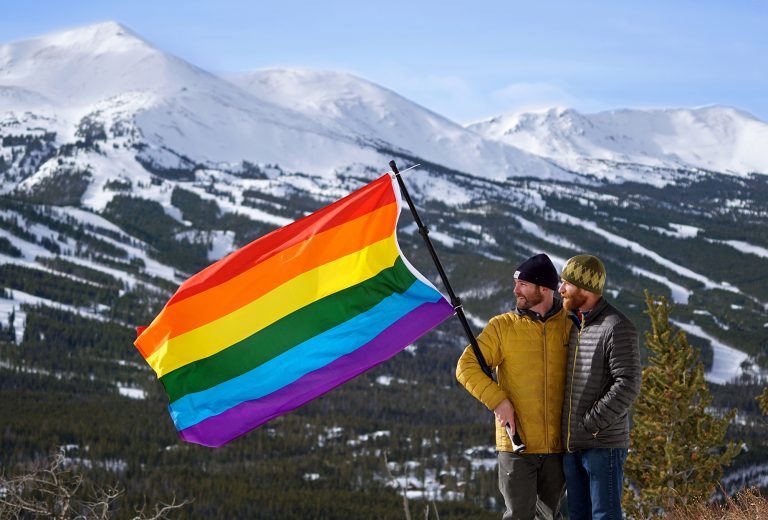 couple with pride flag mountains in background
