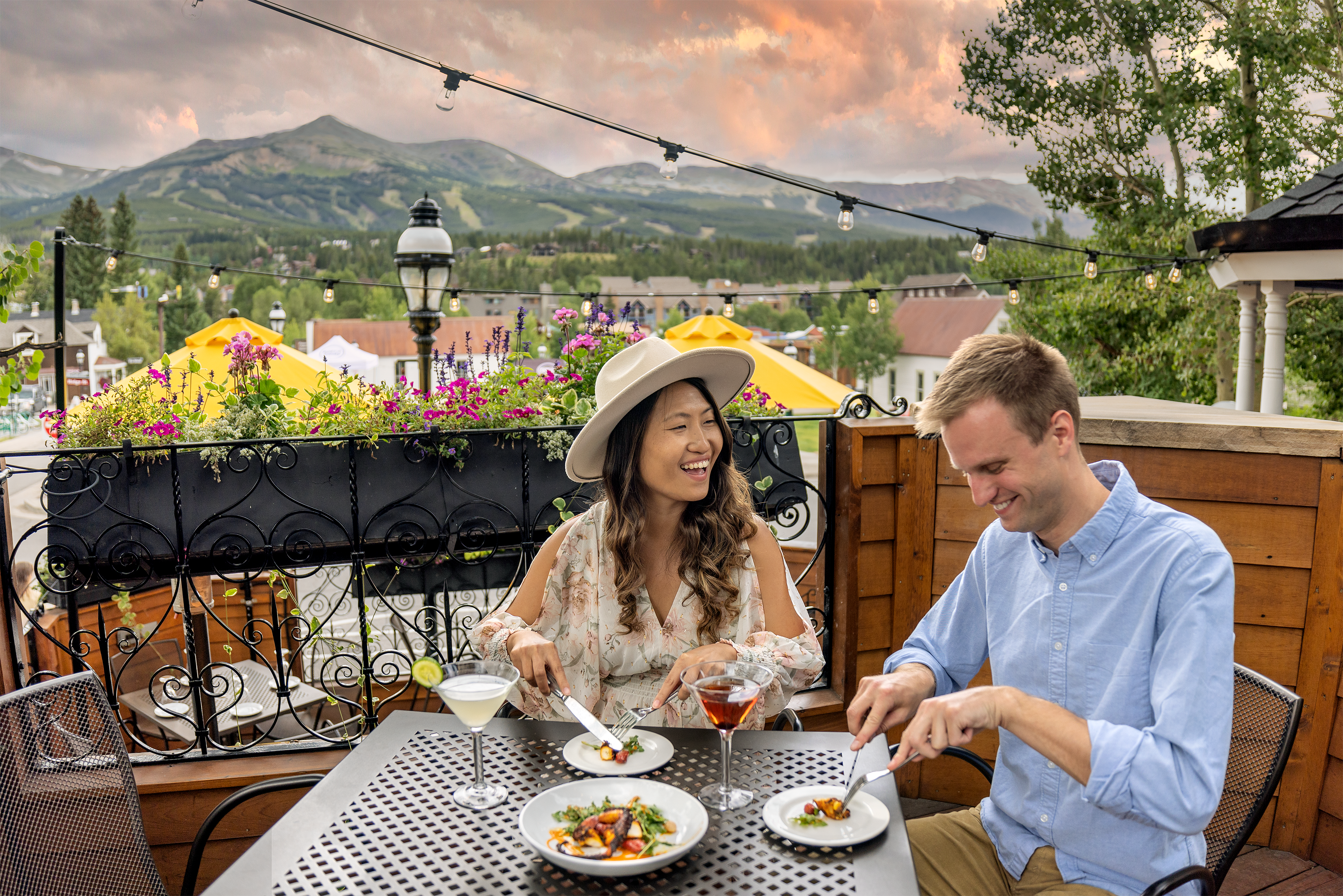 Two people dining on a patio during sunset.